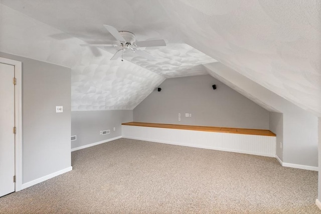 additional living space featuring baseboards, carpet flooring, ceiling fan, and lofted ceiling