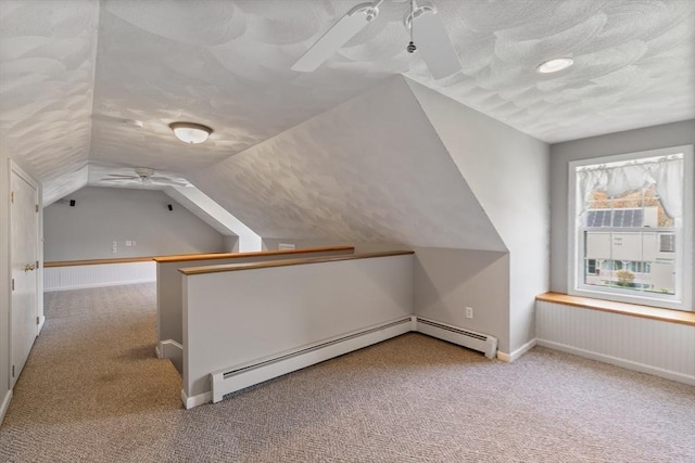 additional living space featuring a ceiling fan, carpet flooring, vaulted ceiling, and baseboard heating