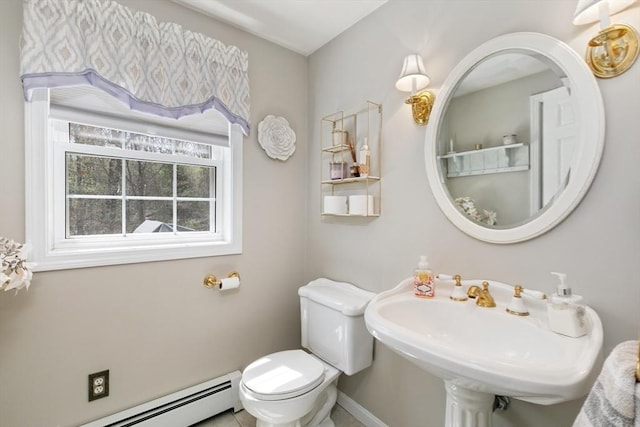 half bath featuring baseboards, a sink, baseboard heating, and toilet