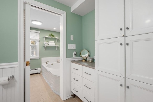 bathroom featuring tile patterned floors, tiled bath, and a baseboard heating unit