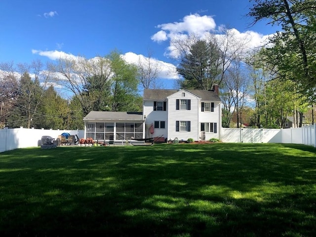 back of house featuring a yard and a sunroom