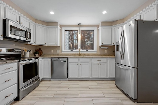 kitchen with appliances with stainless steel finishes, sink, and white cabinets