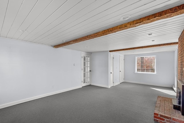 unfurnished living room featuring dark carpet, baseboards, and a wood stove
