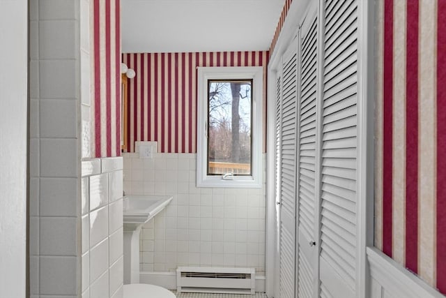 bathroom with tile walls, wallpapered walls, a closet, and a baseboard radiator