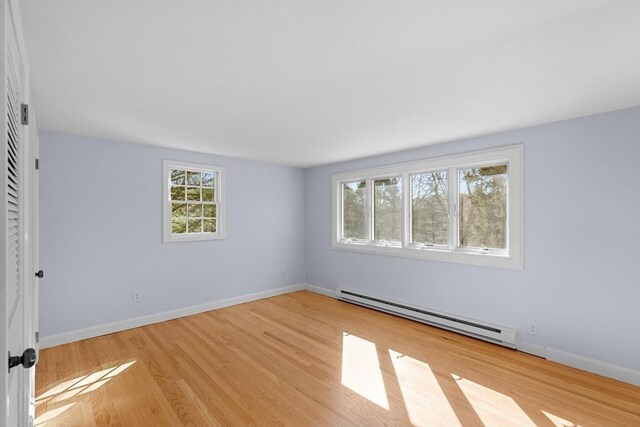 spare room featuring baseboards, wood finished floors, and baseboard heating