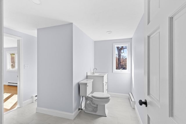 bathroom with a baseboard heating unit, plenty of natural light, a baseboard radiator, and toilet
