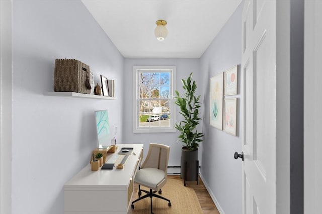 sitting room with baseboard heating, baseboards, and light wood-type flooring