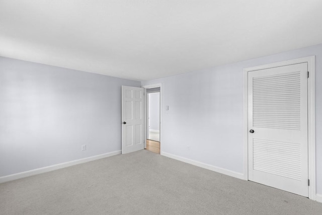 carpeted spare room featuring baseboards