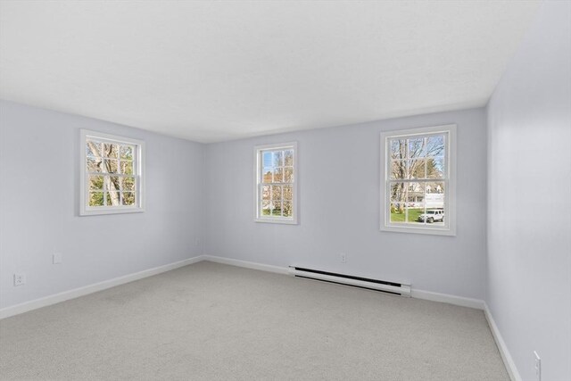 carpeted empty room with a baseboard radiator, baseboards, and plenty of natural light