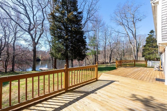 wooden terrace with a yard and a water view