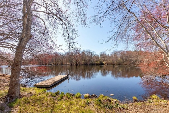 view of dock with a water view and a wooded view