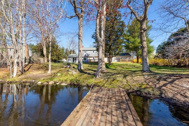 view of dock featuring a lawn