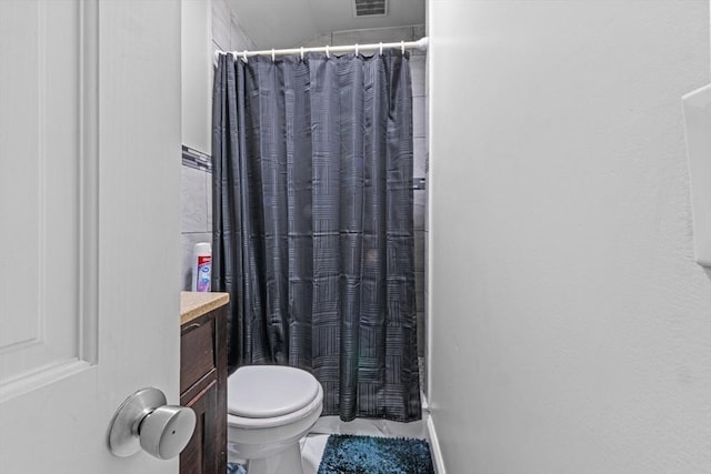 bathroom with walk in shower, vanity, and toilet