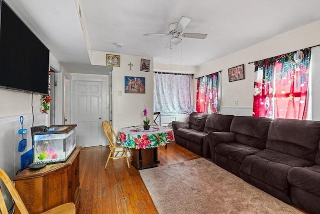 living room with ceiling fan and dark hardwood / wood-style flooring