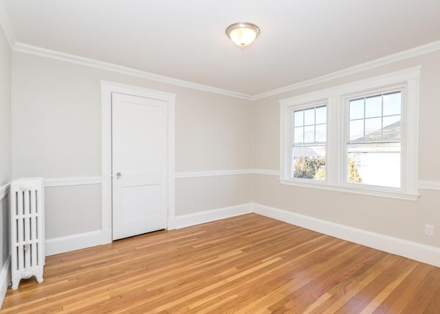 unfurnished room with radiator, ornamental molding, and light wood-type flooring