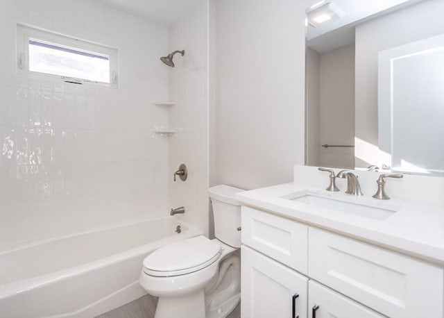 full bathroom featuring tiled shower / bath combo, vanity, and toilet