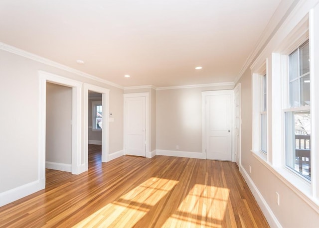 spare room featuring crown molding and light wood-type flooring