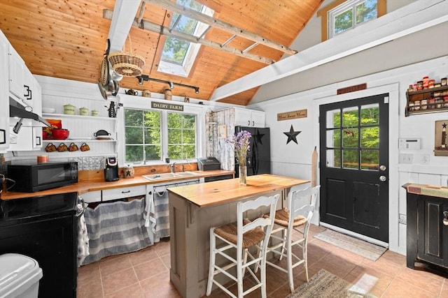 18 Russell Holmes Way, Carver, MA 02330 - kitchen featuring wooden counters, black appliances, wooden ceiling, a skylight, and light tile patterned floors