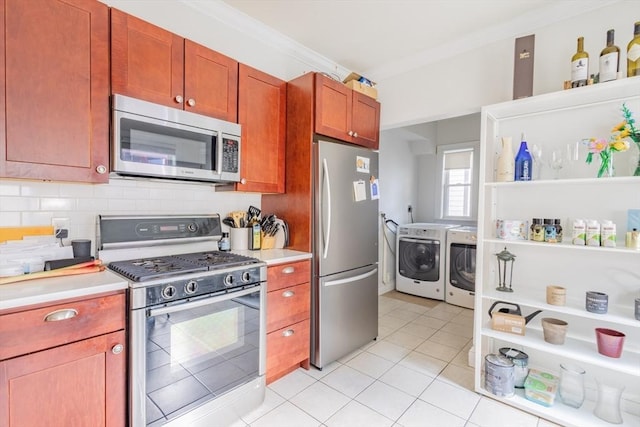 28 Edison Grn Unit 2, Boston, MA 02125 - kitchen featuring stainless steel appliances, independent washer and dryer, crown molding, light countertops, and decorative backsplash