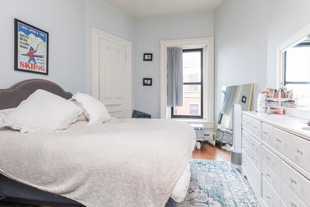 bedroom with wood finished floors and multiple windows