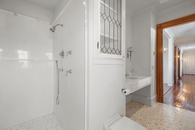 full bathroom featuring crown molding and tiled shower