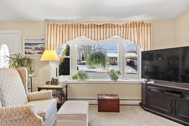 living area with a baseboard heating unit and light carpet