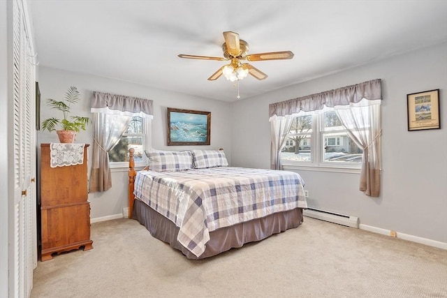 bedroom featuring a baseboard heating unit, light carpet, ceiling fan, and a closet