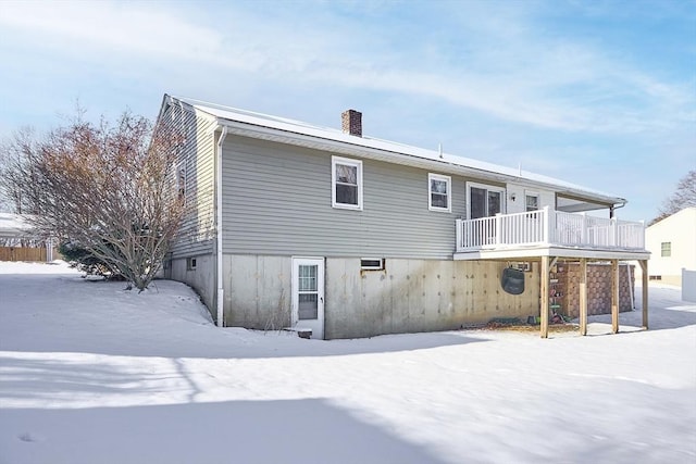 snow covered house featuring a balcony