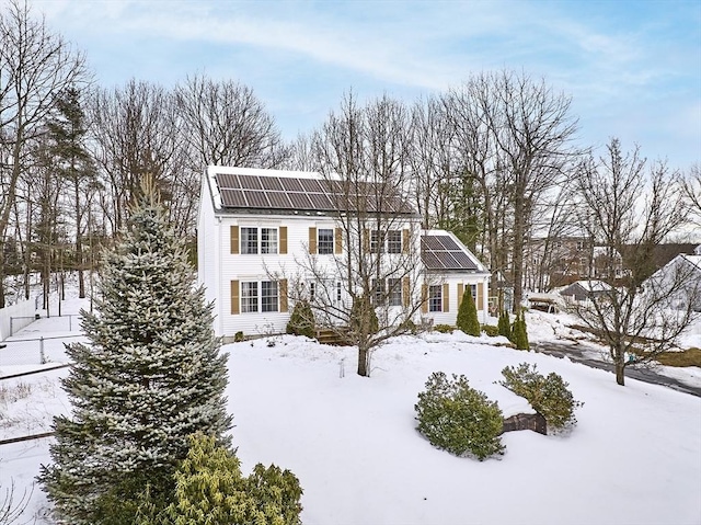 view of front of house featuring solar panels and a gambrel roof