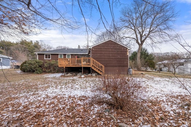 snow covered rear of property featuring a deck