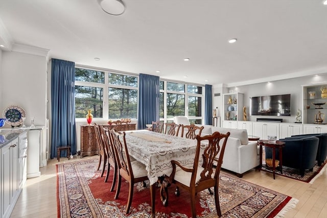 dining area featuring ornamental molding and light hardwood / wood-style floors