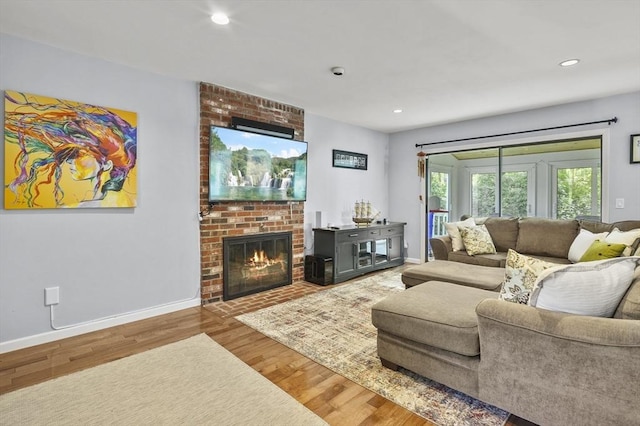 79 Flanagan Dr, Framingham, MA 01701 - living room with wood finished floors, baseboards, recessed lighting, and a brick fireplace