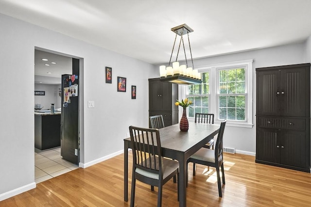 79 Flanagan Dr, Framingham, MA 01701 - dining space with light wood-type flooring, a chandelier, and baseboards