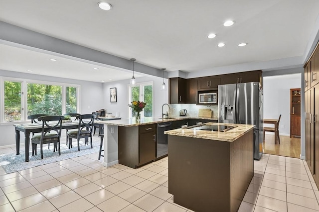 79 Flanagan Dr, Framingham, MA 01701 - kitchen with appliances with stainless steel finishes, dark brown cabinets, light stone counters, light tile patterned flooring, and a peninsula