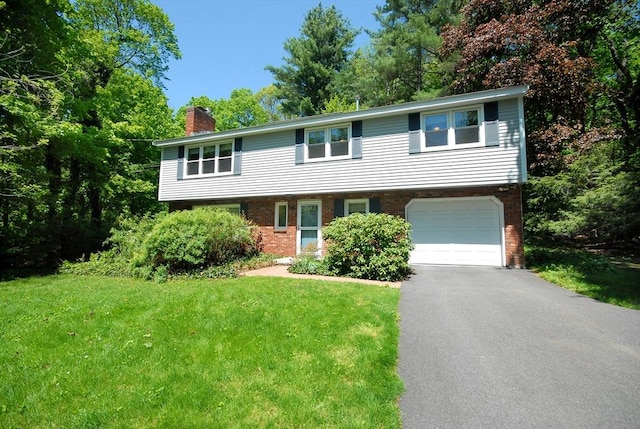 14 Sudbury Rd, Stow, MA 01775 - view of front of house with a chimney, brick siding, a garage, and a front lawn