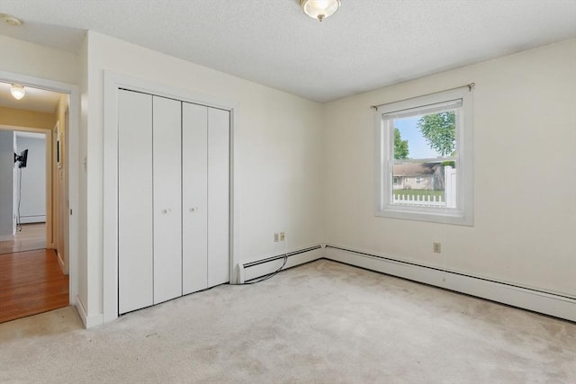 1064 James St Unit 1064, Chicopee, MA 01022 - unfurnished bedroom with light colored carpet, a closet, a baseboard heating unit, and a textured ceiling
