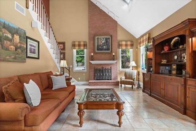 54 Wagon Rd, Walpole, MA 02081 - living room with high vaulted ceiling, stairway, plenty of natural light, track lighting, and a brick fireplace
