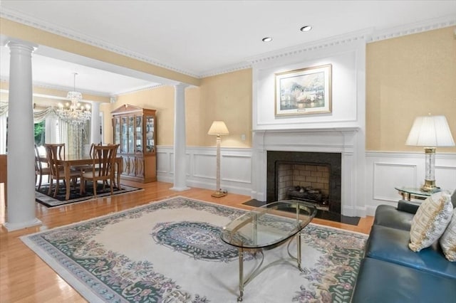 54 Wagon Rd, Walpole, MA 02081 - living room with decorative columns, wood finished floors, a chandelier, a decorative wall, and a wainscoted wall