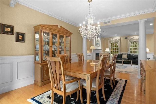 54 Wagon Rd, Walpole, MA 02081 - dining area with light wood finished floors, a wainscoted wall, a decorative wall, a chandelier, and ornate columns