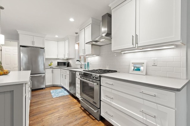 35 Orchard Rd, Milton, MA 02186 - kitchen with stainless steel appliances, wall chimney range hood, light countertops, tasteful backsplash, and recessed lighting