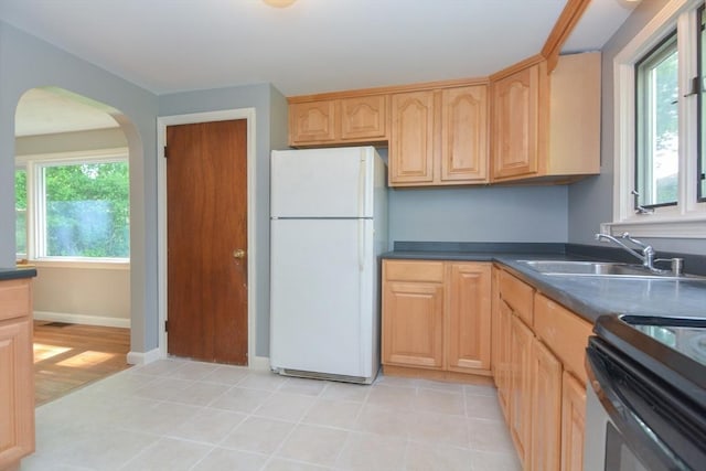 80 Dobbins St, Waltham, MA 02451 - kitchen featuring freestanding refrigerator, a sink, arched walkways, dark countertops, and light brown cabinetry