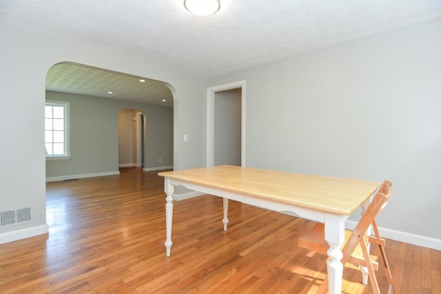 80 Dobbins St, Waltham, MA 02451 - dining space featuring arched walkways, baseboards, and light wood-style floors