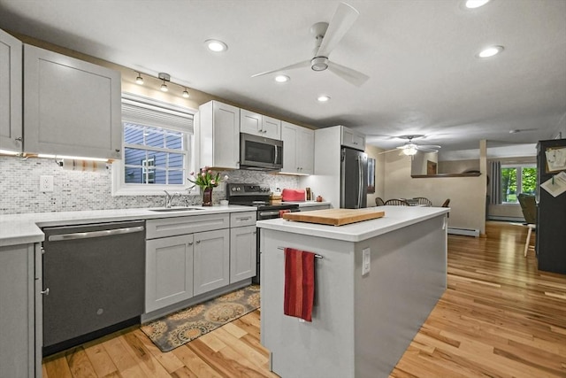 11 Fern Ave, Amesbury, MA 01913 - kitchen with stainless steel appliances, a ceiling fan, light wood-style flooring, a sink, and baseboard heating