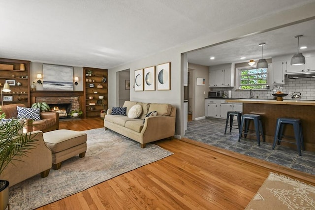 11 Fern Ave, Amesbury, MA 01913 - living room with dark wood-type flooring, baseboards, a fireplace, built in shelves, and recessed lighting