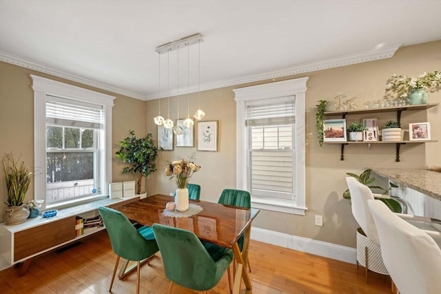 dining space with an inviting chandelier, wood-type flooring, crown molding, and a wealth of natural light