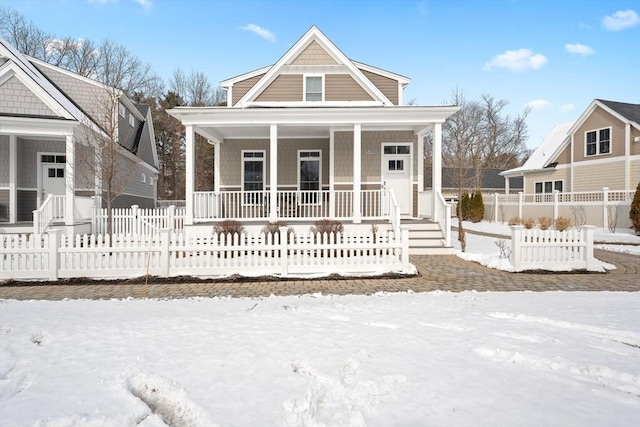 view of front facade with covered porch and a fenced front yard