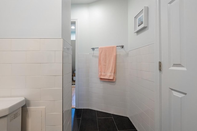 bathroom featuring tile walls, tile patterned flooring, wainscoting, and vanity