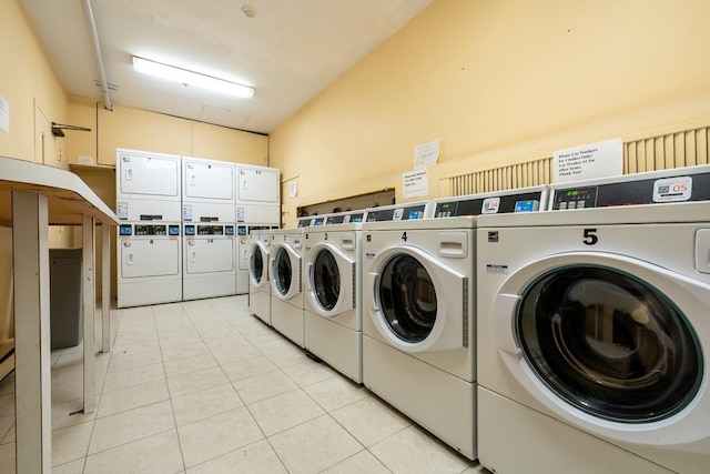 communal laundry room featuring stacked washer / drying machine, light tile patterned floors, and washer and dryer