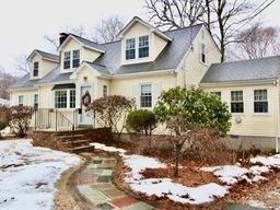 cape cod home with a garage