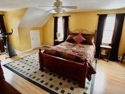 bedroom with lofted ceiling, ceiling fan, and light wood-type flooring